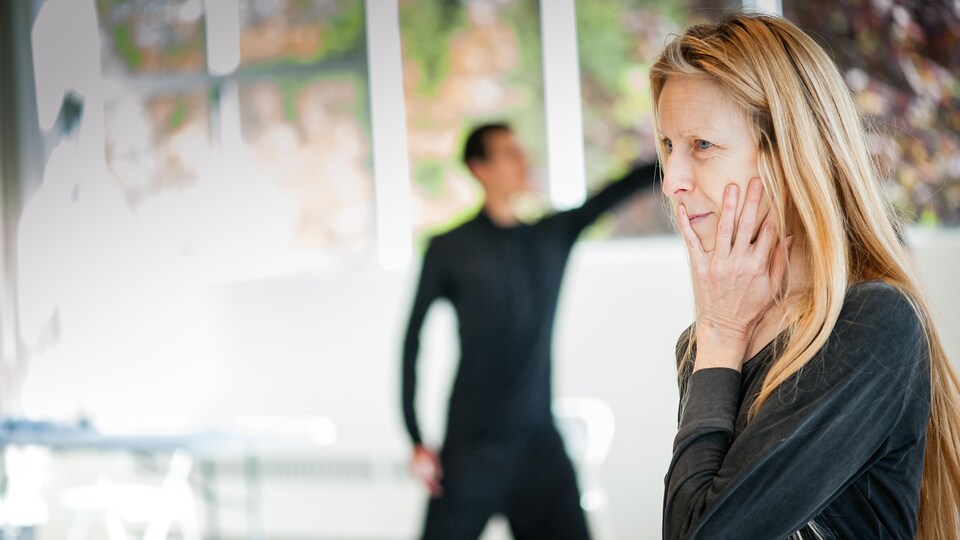Marie Chouinard est de profil, une main sur la joue, et regarde devant elle.