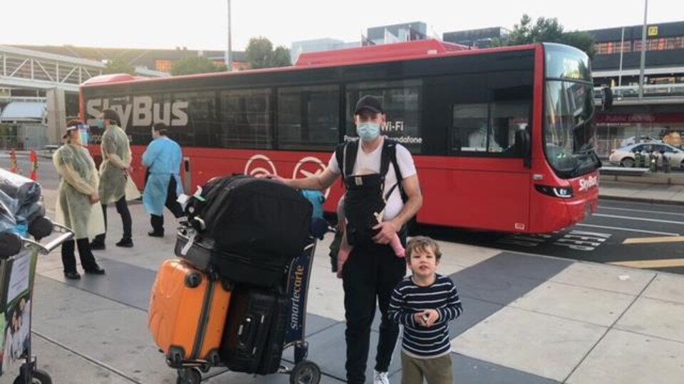 Le père et ses enfants devant un autobus.