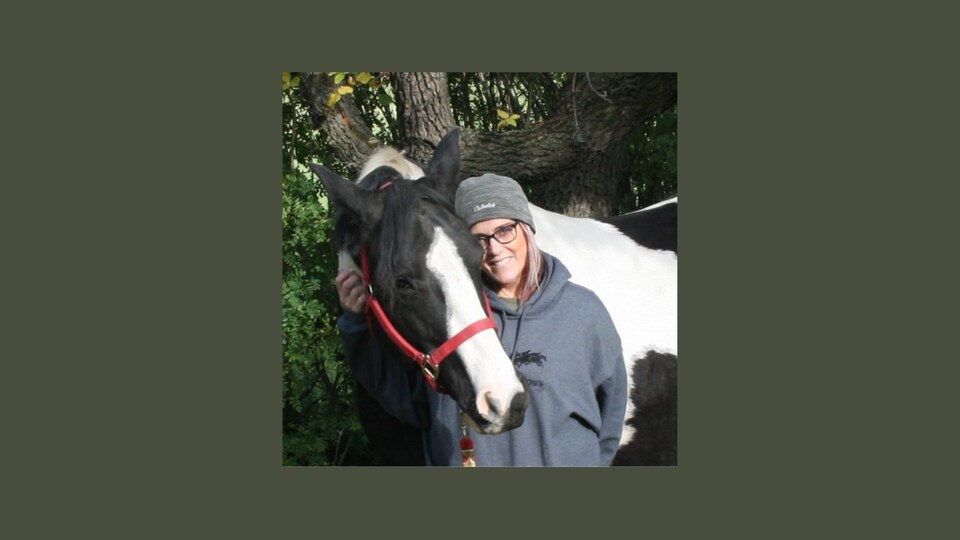 Marie-France Magnin et un cheval au pelage noir et blanc.