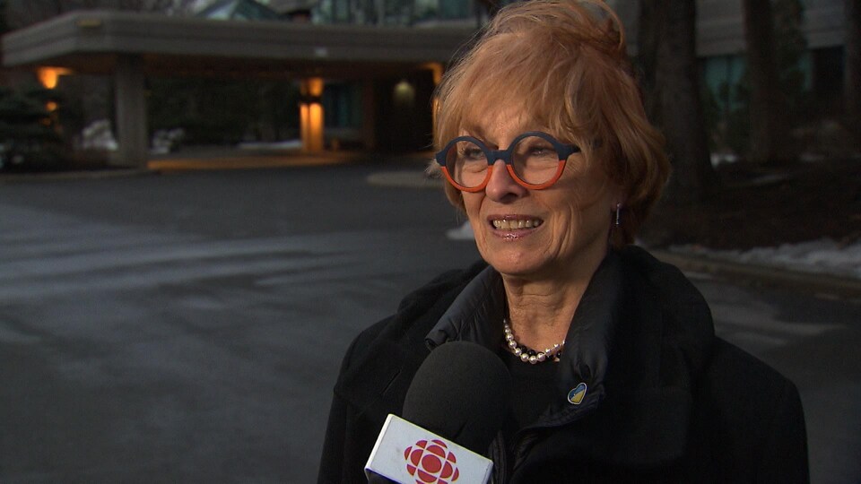 Une femme parlant devant un micro de Radio-Canada.