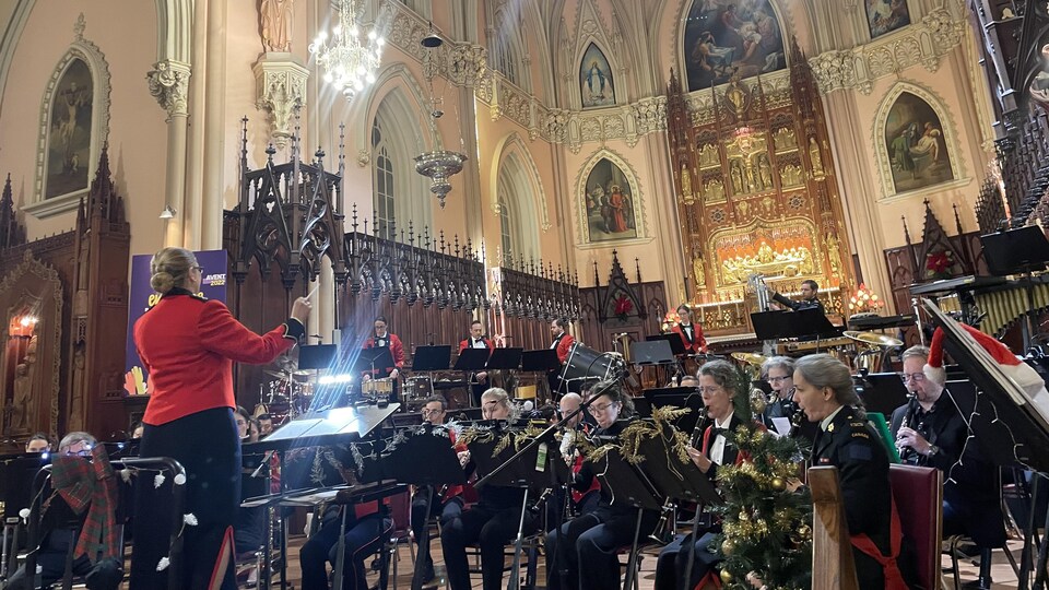 La cheffe d'orchestre Marie-Perle Broadley manie la baguette devant les musiciens dans l’église de la Nativité-de-Notre-Dame de Beauport. 