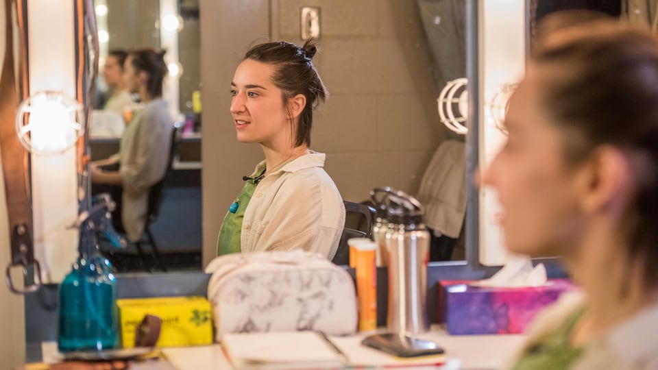 La comédienne Marie-Ève Fontaine est assise devant un miroir, dans une salle de maquillage.