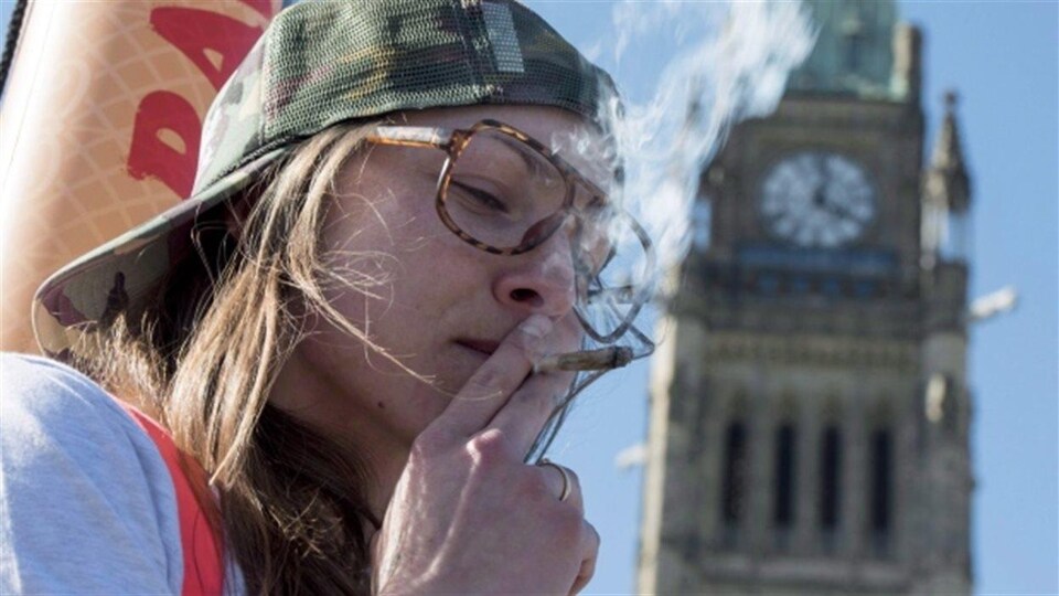 Un jeune fume un joint de marijuana