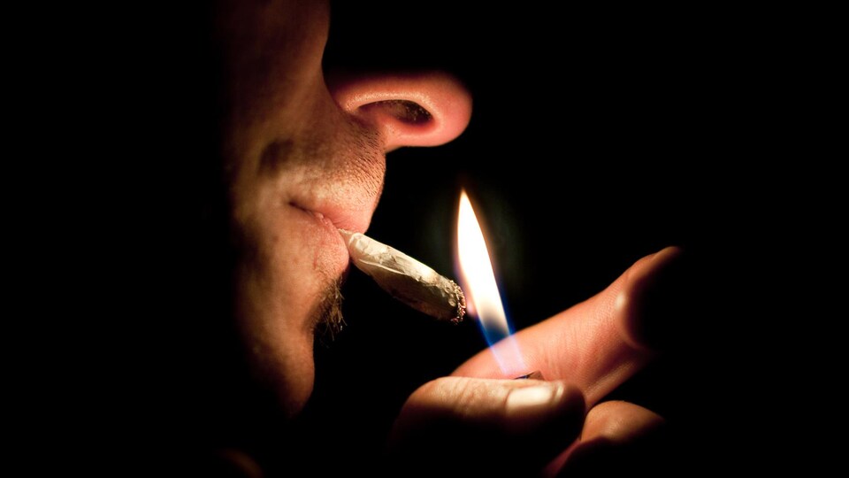Un homme s'allume un joint