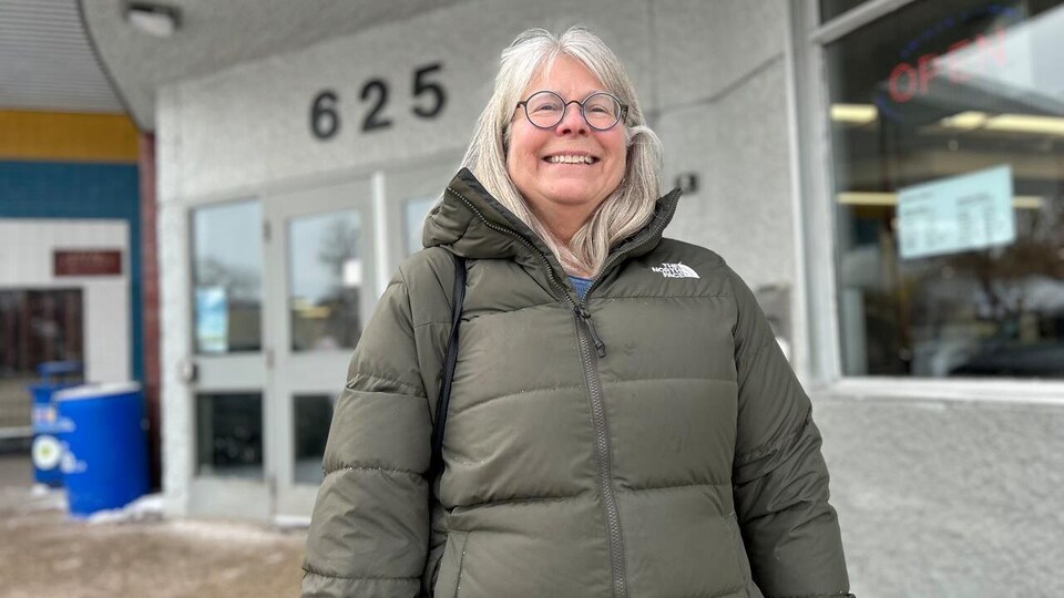 Marilyn Gill devant une bibliothèque municipale.