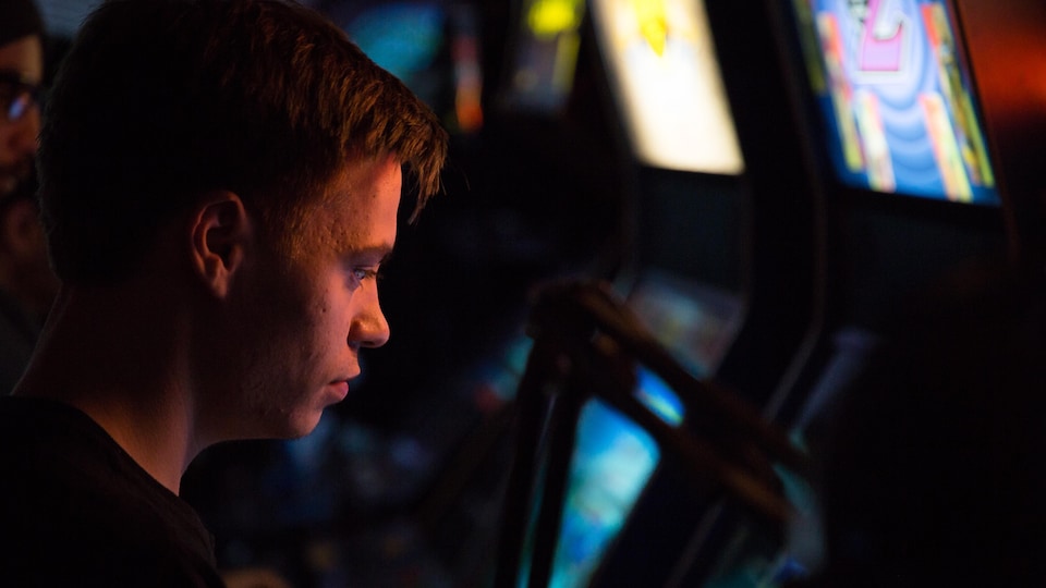 Félix Locas regarde l'écran d'une arcade en attendant de poursuivre le tournoi.