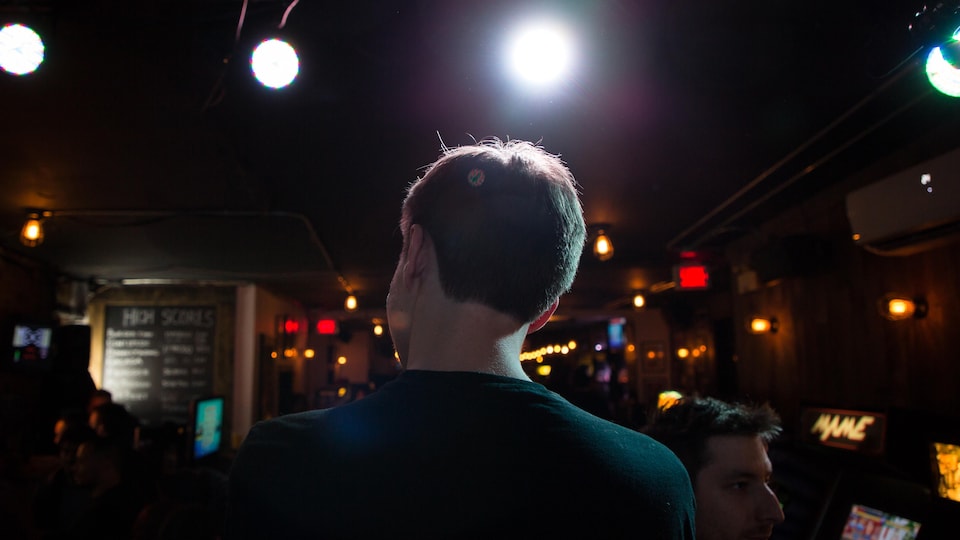 Photographié de dos, Félix Locas observe la petite foule réunie à l'occasion du tournoi auquel il participe.