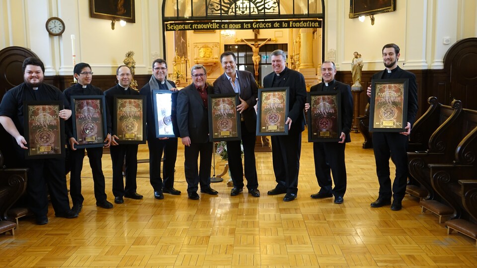 Mario Pelchat, les huit prêtes et le maire de Québec, Régis Labeaume soulignent le disque or de l'album Agnus Dei.