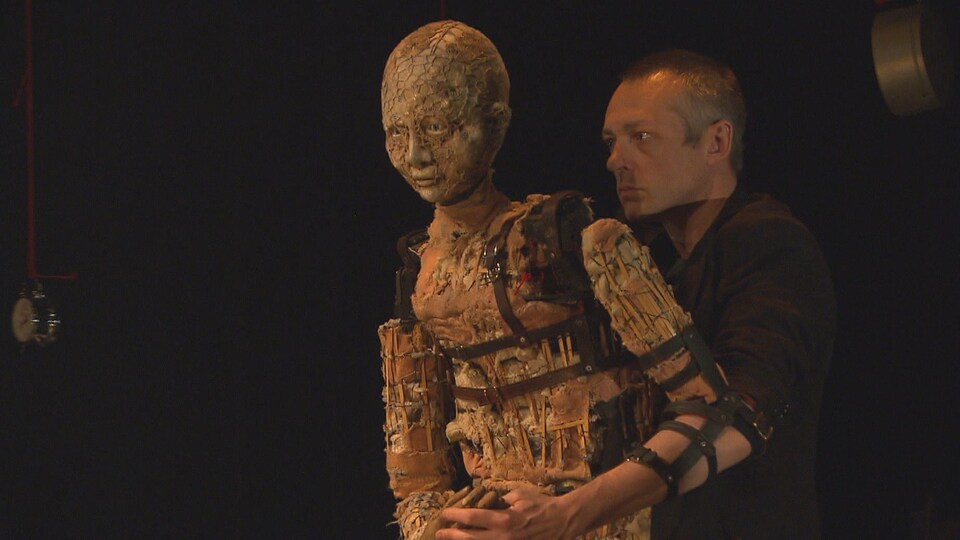 Un marionnettiste et la marionnette au centre de la pièce.