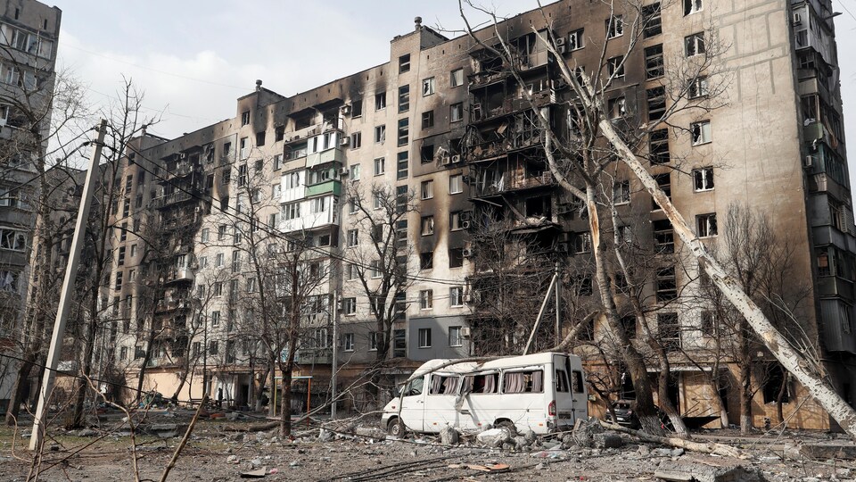 Un immeuble d'habitation et un véhicule détruits après des bombardements.