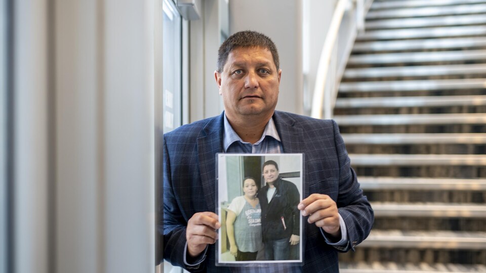 Le chef du Conseil tribal de Saskatoon, Mark Arcand, le 7 septembre 2022, tient une photo de sa sœur tuée lors des attaques au couteau survenues le 4 septembre au sein de la Nation crie James Smith, en Saskatchewan.