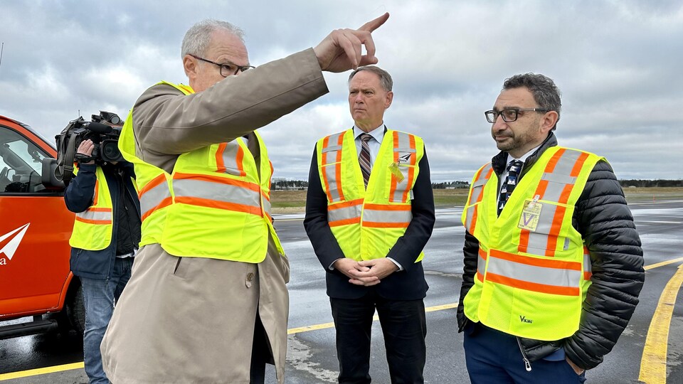 Le président et chef de la direction de l'aéroport international d'Ottawa, Mark Laroche avec le député fédéral d'Ottawa-Sud, David McGuinty et le ministre fédéral des Transports, Omar Alghabra sur une voie de l'aéroport.