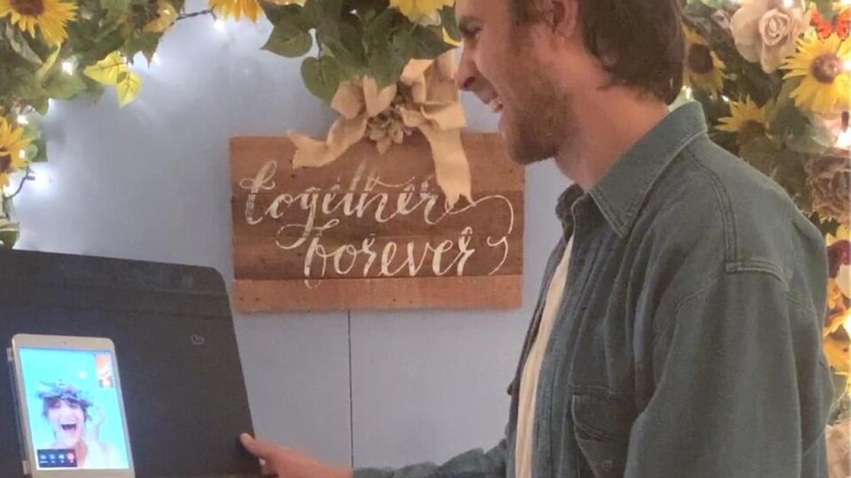 Un homme regarde un iPad et sourit.