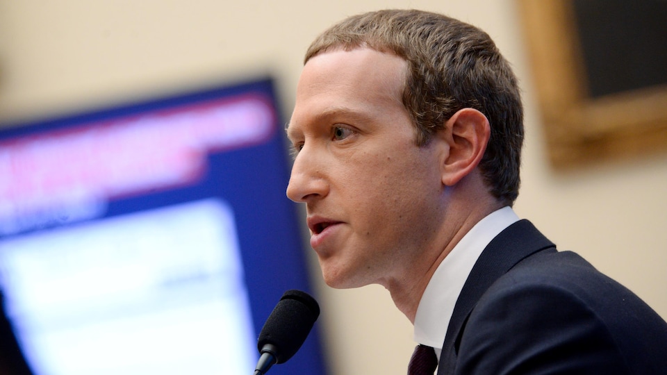 De profil, Mark Zuckerberg parle au micro lors d'une audience au Sénat américain.