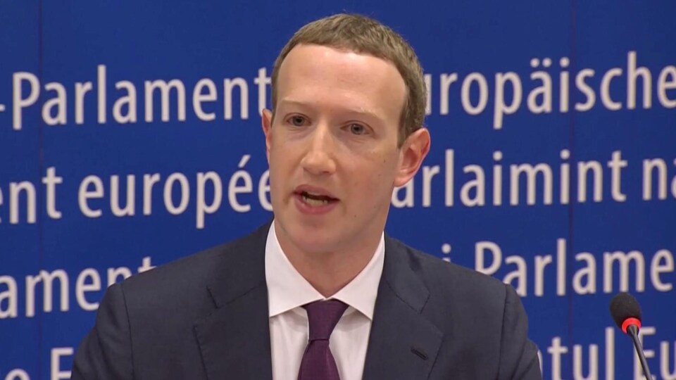 Le président-directeur général de Facebook, Mark Zuckerberg, devant un micro lors d'une audition devant le Parlement européen.