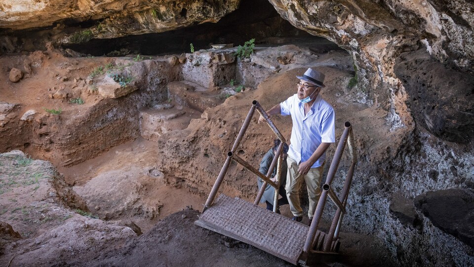 Deux archéologues marchent devant la grotte des Contrebandiers.