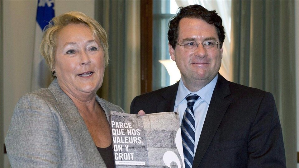 Bernard Drainville et Pauline Marois posent avec un document dans les mains.