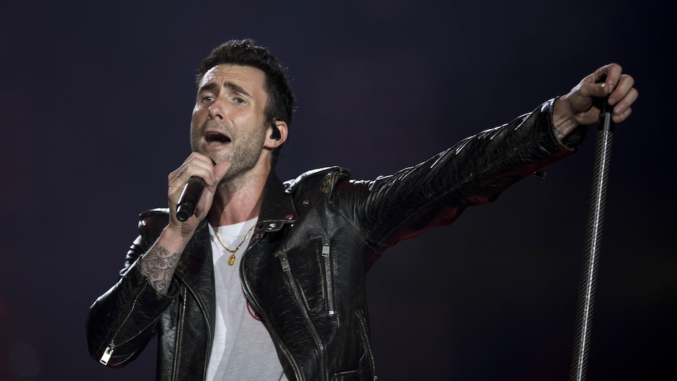 Adam Levine, du groupe Maroon 5, chante sur scène lors d'un concert.