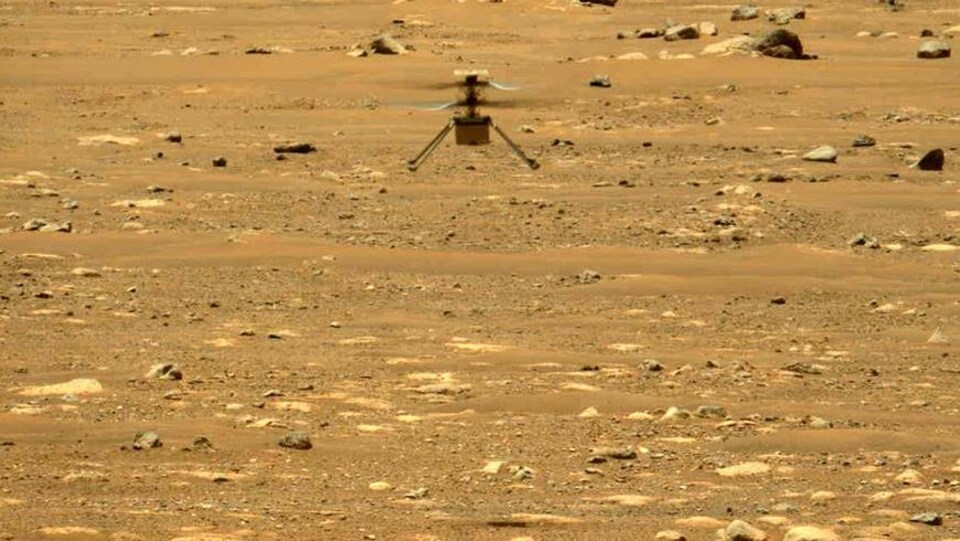 L'hélicoptère vole au-dessus de la surface martienne.