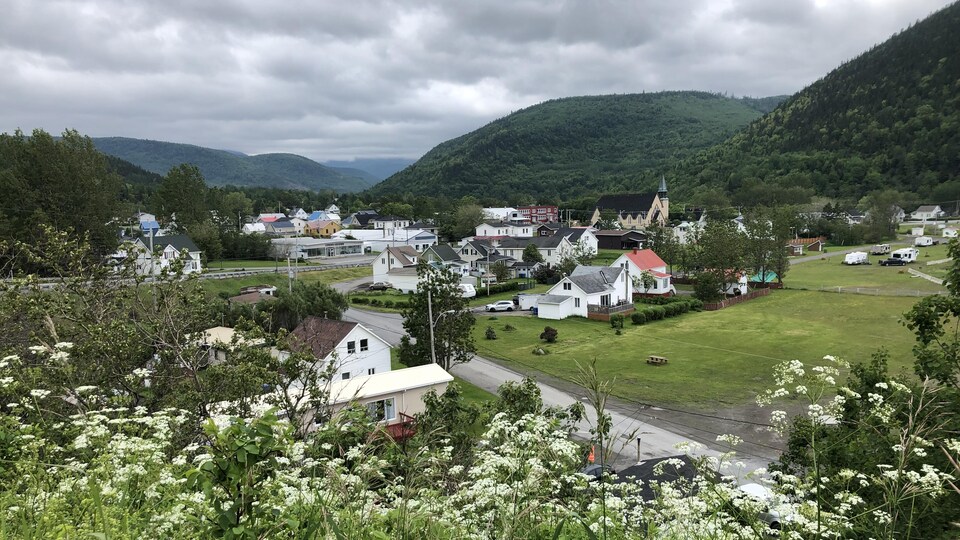 Le village et ses maisons sont au pied des monts Chic-Chocs, en arrière-plan.