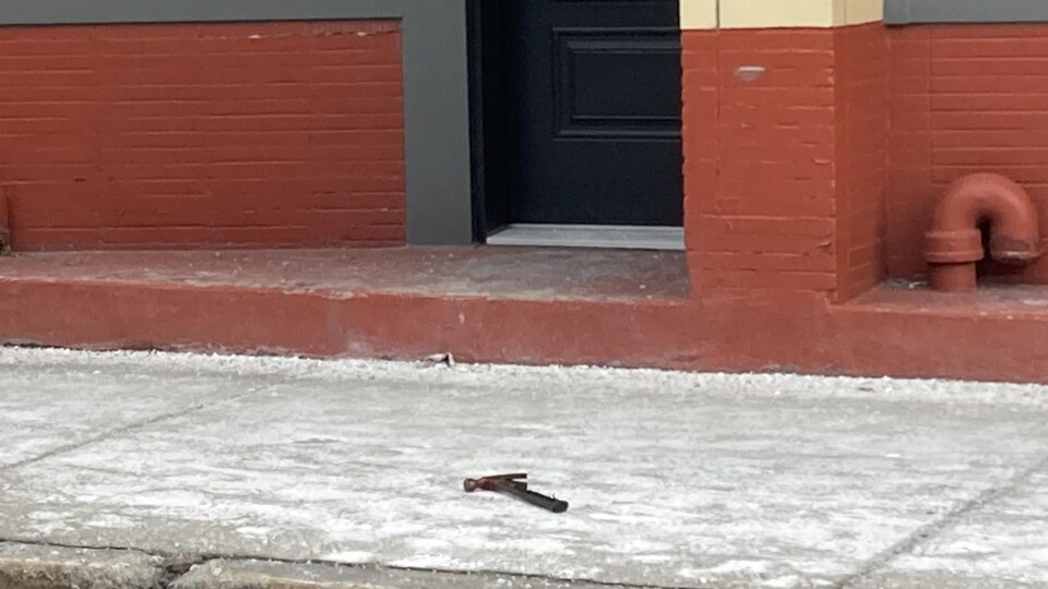 Un marteau gît au sol sur le trottoir de la rue du Pont.