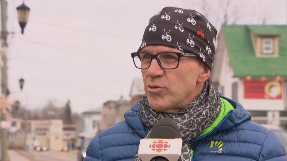 Martin Deschênes en entrevue sur le trottoir d'une rue passante de Montebello.