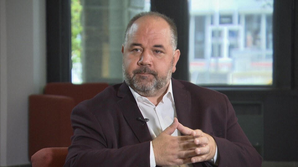 Martin Francoeur assis dans un fauteuil durant une entrevue.