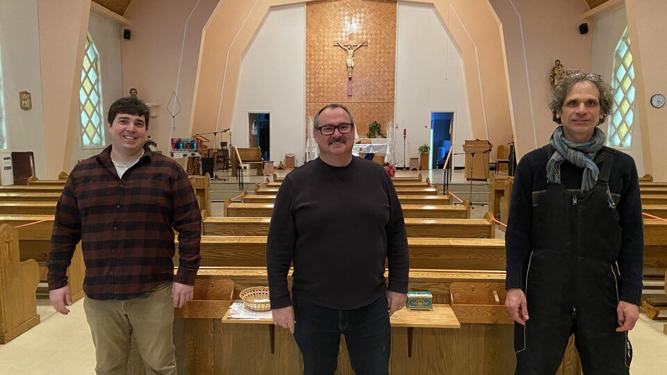 Trois hommes debout dans une église