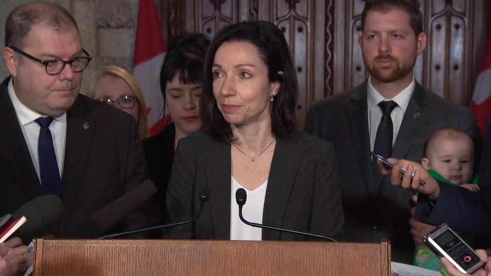 La chef du Bloc québécois, Martine Ouellet, répond aux questions des journalistes sous le regard du député Mario Beaulieu (à gauche), le 28 février 2018.