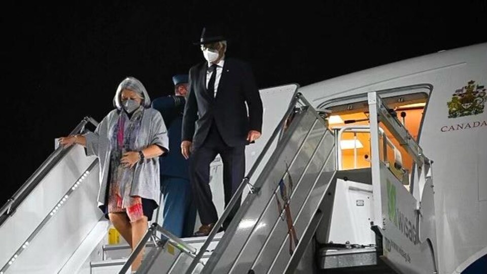 Un homme et une femme descendent les marches d'un avion.