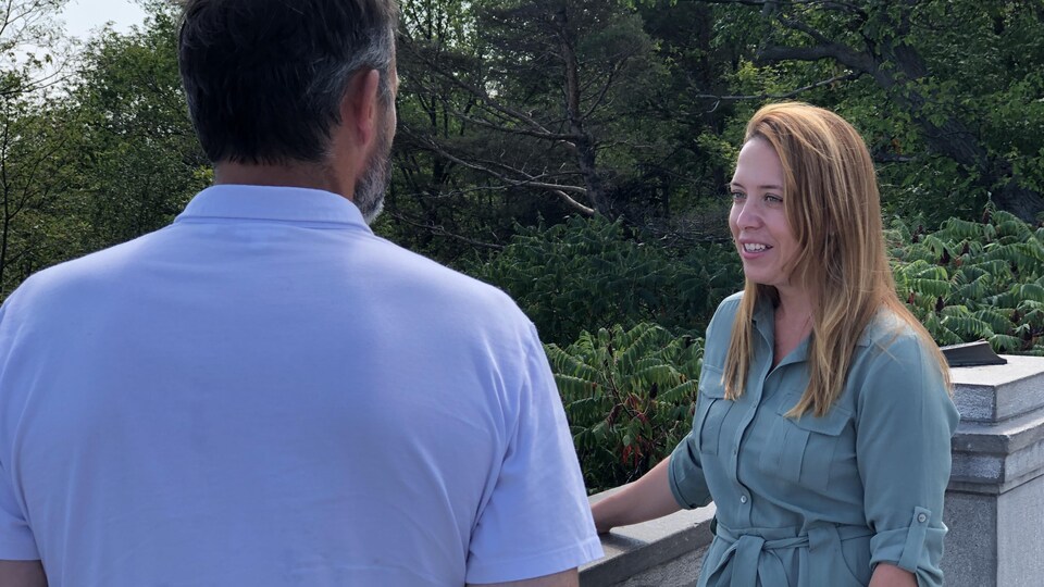 Mme Charbonneau discute avec un homme au sommet du mont Royal.