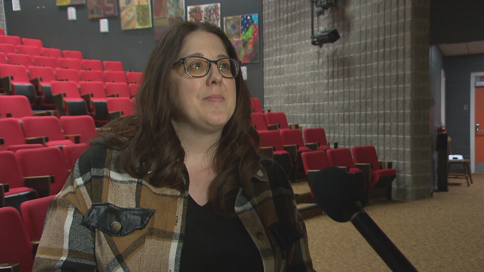 Une femme en entrevue dans une salle de spectacle.