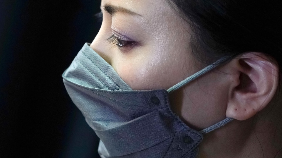 Une femme porte un masque à Tokyo, au Japon.