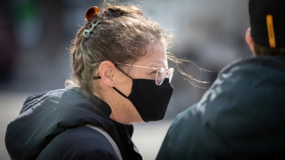 Une femme porte un masque.