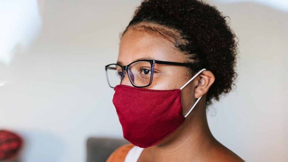 Une femme portant un masque en tissu.