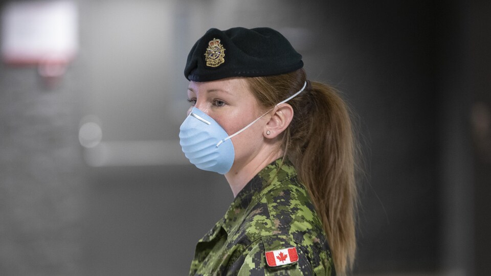 Une militaire avec un masque.