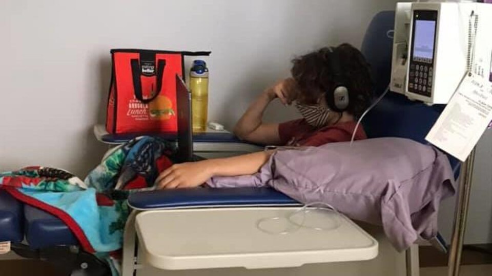 Jérémie qui subit un traitement portant un masque.