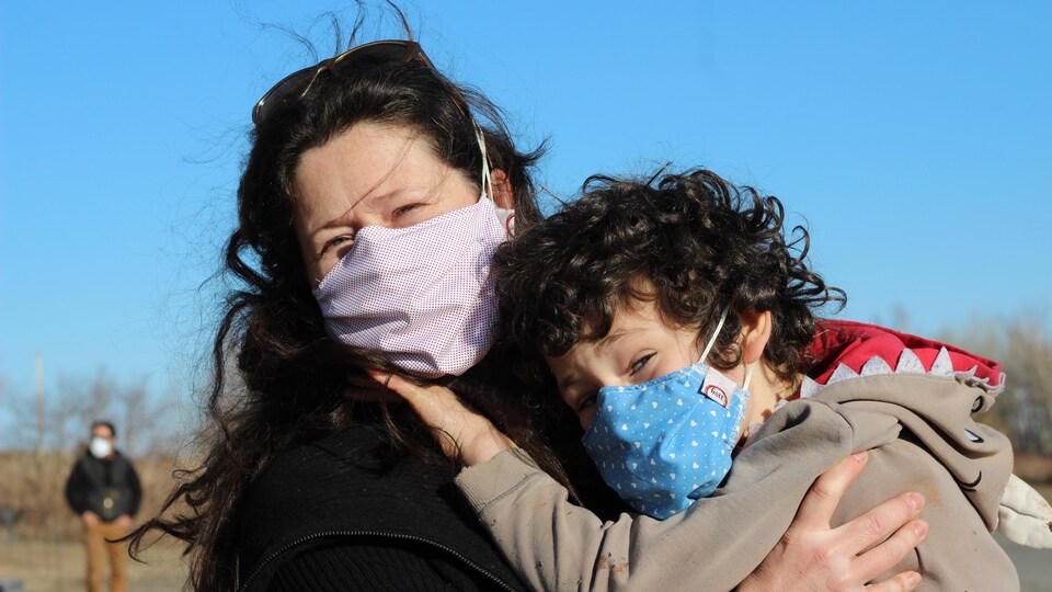 Une mère et son enfant portent un masque de l'entreprise.