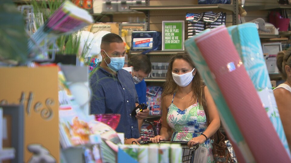Deux personnes portent le masque dans un commerce.