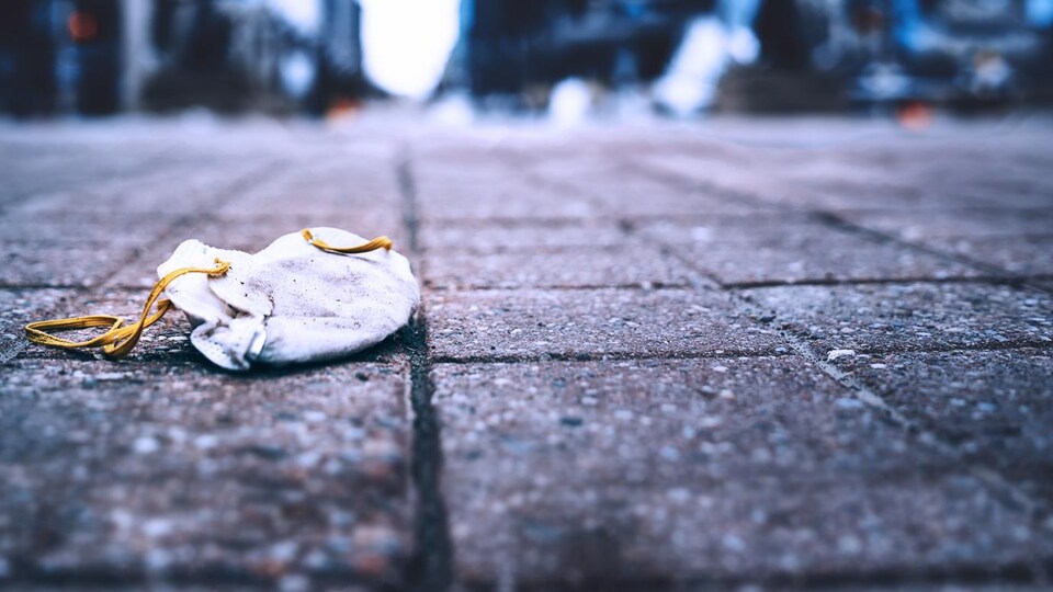 Un masque N95 laissé au sol sur la rue Sparks, au centre-ville d'Ottawa le 18 mars 2020.