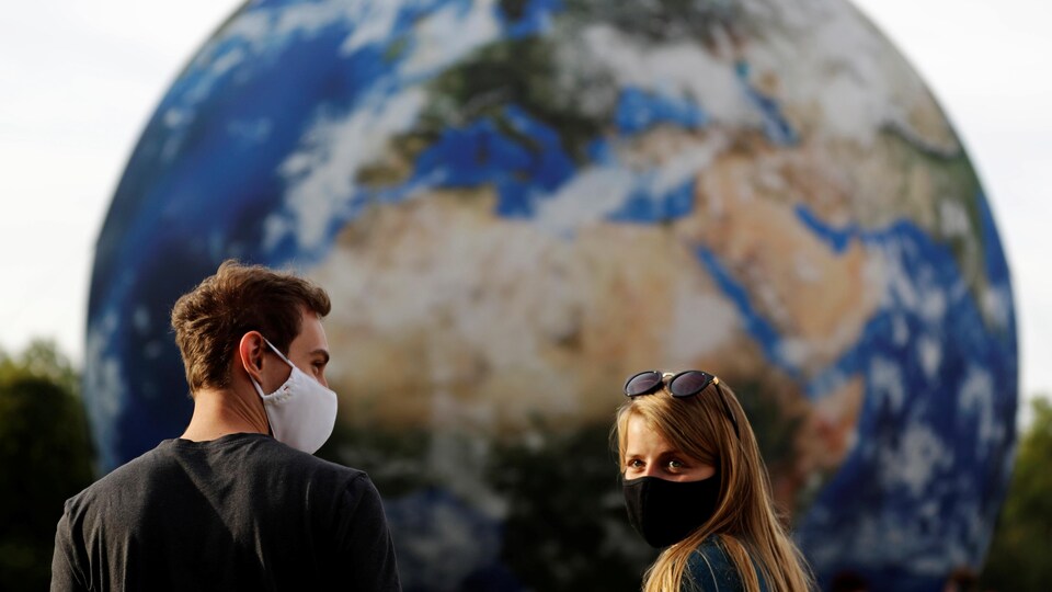 Un homme et une femme devant une Terre géante gonflable.