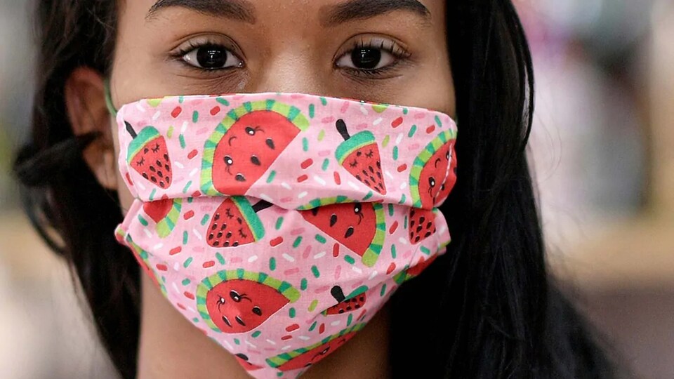 Une femme porte un masque à motif de melons d'eau.