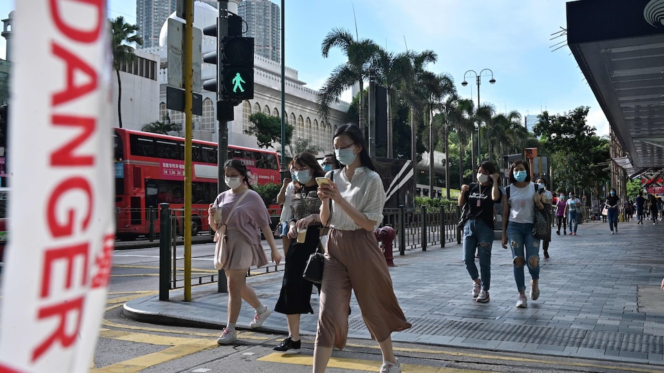 Des piétons masqués traversant la rue à Hong Kong