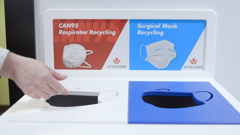 Des contenants de récupération de masques à usage unique.