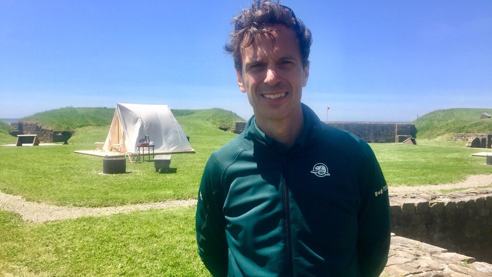 Mathieu D'Astous souriant devant une tente au Fort-Beauséjour Fort-Cumberland 