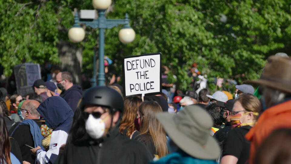 Une foule avec une pancarte.