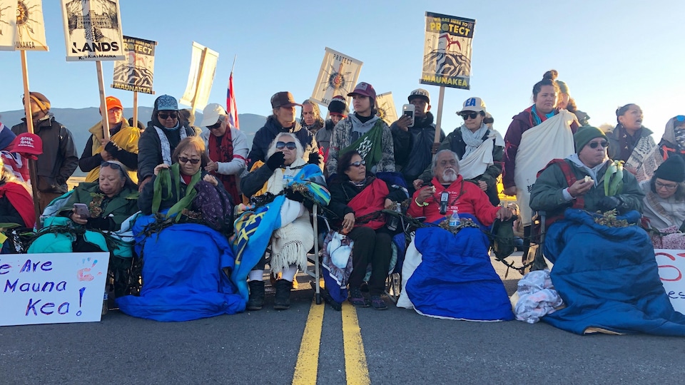 Une rangée de manifestants bloque une route d'Hawaï.