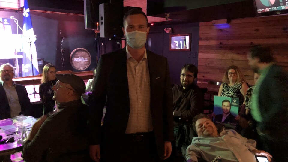 Maxime Blanchette-Joncas se tient debout dans un bar de Rimouski, entouré de partisans.