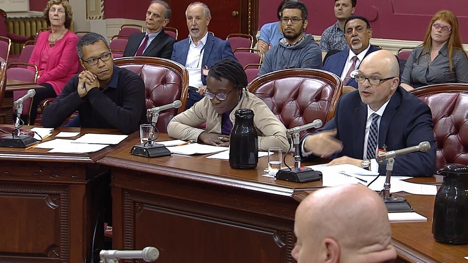 Les trois intervenants assis derrière des micros.