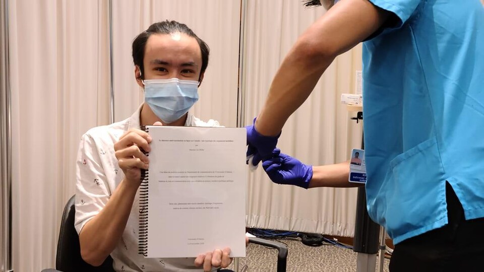 Maxime Lê tient sa thèse tient sa thèse de maîtrise tout en se faisant vacciner. 